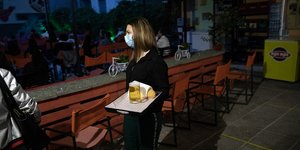 Σερβιτόρα φοράει προστατευτική μάσκα