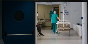 Νοσηλευτές σέρνουν κρεβάτι σε διάδρομο νοσοκομείου