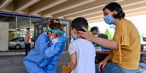 Γιατρός κάνει τεστ για κορωνοϊό σε παιδί υπό το βλέμμα της μητέρας του στον Προμαχώνα