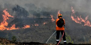 Πυροσβέστης σβήνει φωτιά στο δάσος στις Κεχριές
