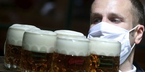 σερβιτόρος με μάσκα και μπύρες