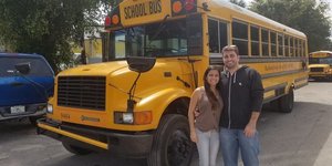 Ζευγάρι ποζάρει μπροστά από σχολικό λεωφορείο