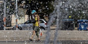 Γυναίκα περπατάει κοντά σε συντριβάνι