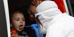 γιατρός παίρνει δείγμα από παιδάκι για κορωνοϊό