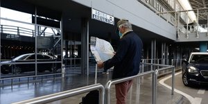 Τουρίστας στο αεροδρόμιο «Μακεδονία» με χάρτη στα χέρια και μάσκα προστασίας από τη μετάδοση του κορωνοϊού
