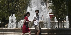 Ανδρας και γυναίκα περπατούν δίπλα σε συντριβάνι