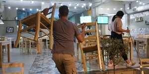 αντρας κουβαλαει καρεκλες 