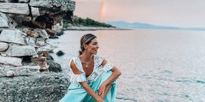 Η Αθηνά Οικονομάκου στο Γύθειο με φόντο το ουράνιο τόξο