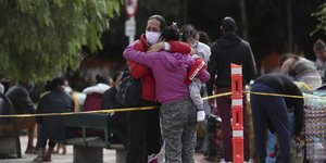 Γυναίκες αγκαλιάζονται στενοχωρημένες φορώντας μάσκες