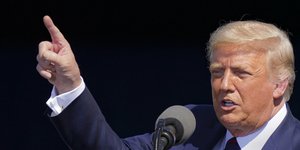 Ο πρόεδρος των ΗΠΑ, Ντόναλντ Τραμπ με ριγέ και το δάχτυλο να δείχνει ψηλά