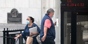 Ανδρας μπαίνει στο χρηματιστήριο της Νέας Υόρκης κρατώντας πλαστικό ποτήρι