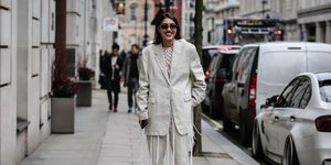 Γυναίκα με λευκό κοστούμι στο δρόμο 