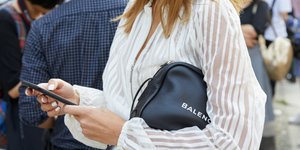 Γυναίκα με λευκό πουκάμισο και μαύρη τσάντα 