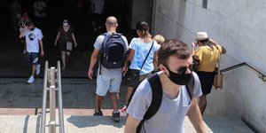 Πολίτες με μάσκες σε είσοδο του μετρό