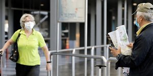 Τουρίστες φορούν μάσκες στο αεροδρόμιο