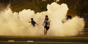 Διαδηλωτές τρέχουν μακριά από καπνούς από δακρυγόνα