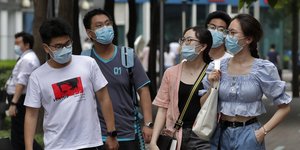 Νέοι Κινέζοι περπατούν με μάσκες για τον κορωνοϊό