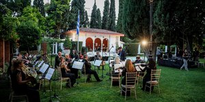 Στιγμιότυπο από την δεξίωση για την αποκατάσταση της Δημοκρατίας: Η ορχήστρα, η ελληνική σημαία και στο βάθος το κιόσκι