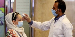 Γυναίκα στο Ιράν με μάσκα υποβάλλεται σε θερμομέτρηση