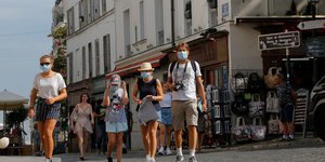 Τουρίστες με μάσκα προστασίας από τον κορωνοϊό στη Μονμάρτη