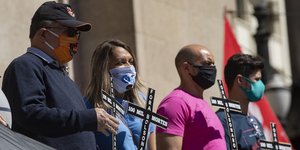 Βραζιλιάνοι κρατούν σταυρούς φορώντας μάσκα για τον κορωνοϊό