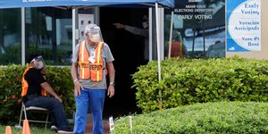 Υπάλληλος με μάσκα και πορτοκαλί γιλέκο στις ΗΠΑ