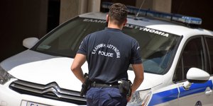 Αστυνομικός μπροστά από περιπολικό