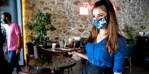 Σερβιτόρα με μάσκα σε καφέ