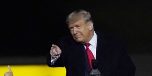 Ο Ντόναλντ Τραμπ με κόκκινη γραβάτα δείχνει με το δάχτυλο σε προεκλογική συγκέντρωση στη Βόρεια Καρολίνα