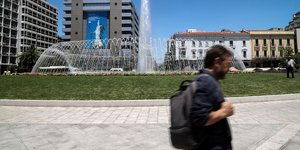 120 δόσεις / Ενας άνδρας περπατά μπροστά από το συντριβάνι της Ομόνοιας