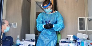 Γιατρός του ΕΟΔΥ κάνει τεστ σε πολίτη