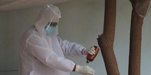 Γιατρός με στολή ρίχνει φάρμακο πάνω στο χέρι του