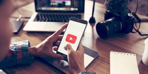 Άνδρας κρατά ένα κινητό με την εφαρμογή του YouTube