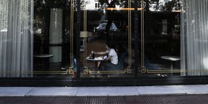 Γυναίκα πίνει καφέ σε κατάστημα 