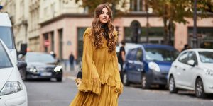 Γυναίκα με κίτρινο, μακρυμάνικο φόρεμα στο δρόμο 