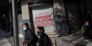 Γυναίκες περπατούν φορώντας μάσκες στο Σαντιάγο