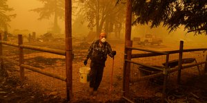 Ανδρας στο Ορεγκον κουβαλάει κουβά για να σβήσει φωτιά