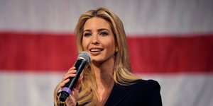 Η Ιβάνκα Τραμπ με μικρόφωνο και φόντο την αμερικανική σημαία