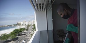 Καθαριστής εργάζεται σε κτίριο στη Βραζιλία φορώντας μάσκα για τον κορωνοϊό