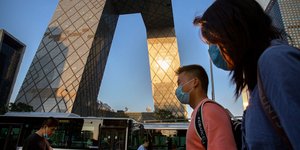 Κινέζοι με μάσκες περπατούν στον δρόμο