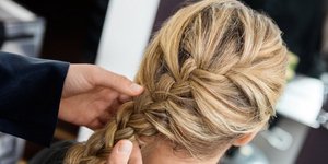 Κομμωτής φτιάχνει πλεξίδα σε γυναίκα