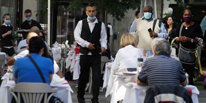 Πελάτες και σερβιτόροι με μάσκες σε εστιατόριο στη Βρετανία