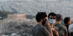 Τουρίστες με μάσκες στο Λυκαβηττό με θέα την Ακρόπολη