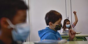 μαθητρια με μασκα σηκωνει χερι