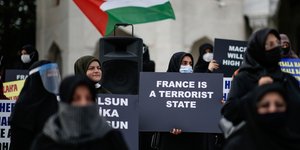 Μαυροφορεμένες γυναίκες κρατούν πλακάτ κατά της Τουρκίας