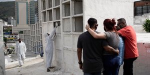 Οικογένεια αγκαλιάζεται σε πρόχειρο νεκροταφείο στην Βραζιλία