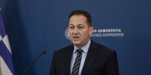 Ο κυβερνητικός εκπρόσωπος με γραβάτα στο Briefing