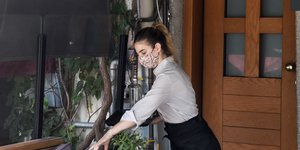 Σερβιτόρα μαζεύει τραπέζι