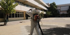 Εργαζόμενος πάει για απολύμανση σε σχολείο