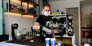 Υπάλληλος βάζει καφέ σε κούπες